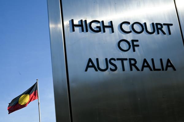 High Court of Australia sign in front of the Aboriginal flag
