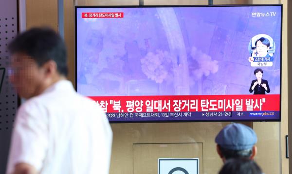 Passersby watch a news report on North Korea's interco<em></em>ntinental ballistic missile launch at Seoul Station in Seoul on Wednesday. (Yonhap)